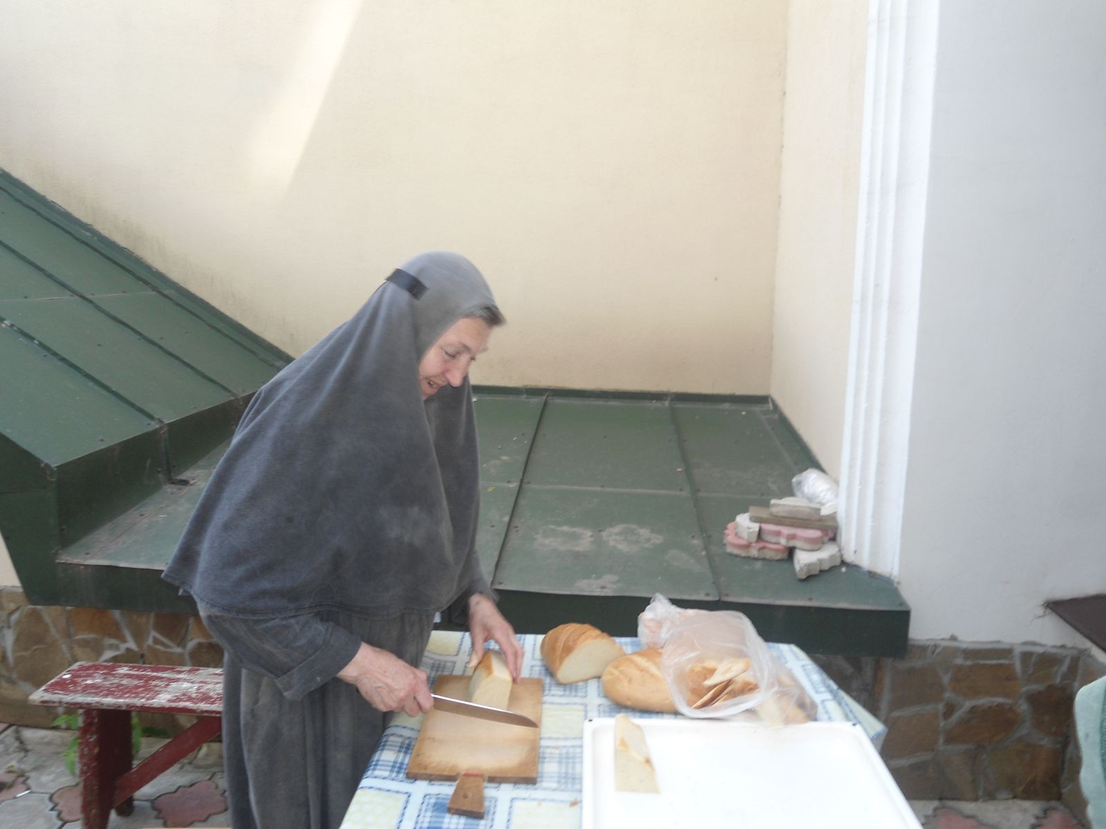Монахиня режет хлеб