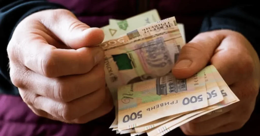 Чоловік тримає в руках гроші