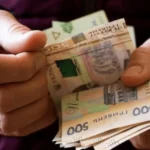 Чоловік тримає в руках гроші