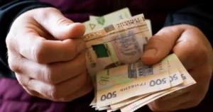 Чоловік тримає в руках гроші