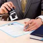 Чоловік у костюмі ставить печатку на документі