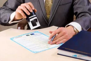 Чоловік у костюмі ставить печатку на документі