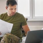Чоловік у військовій формі і ноутбуком