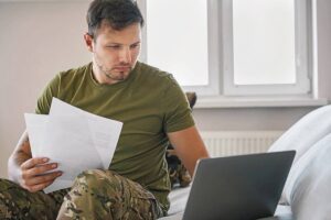 Чоловік у військовій формі і ноутбуком
