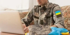 Чоловік у військовій формі з ноутбуком