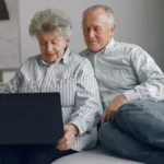 Літні чоловік і жінка з ноутбуком