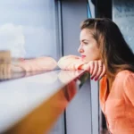 Двчина дивиться у вікно