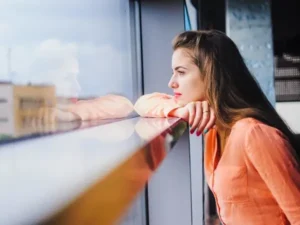 Двчина дивиться у вікно