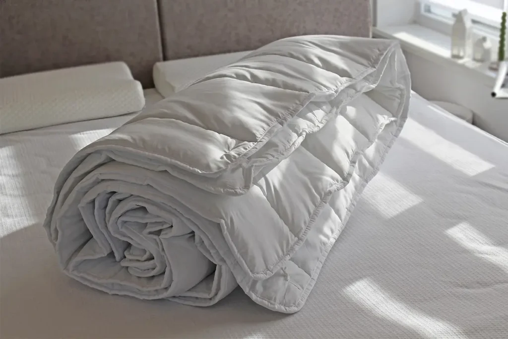 Біла ковдра на ліжку