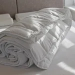 Біла ковдра на ліжку