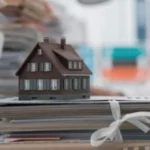 Макет будинку на папках з документами