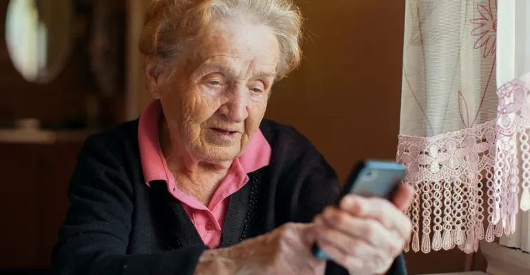 Пенсионерка с телефоном в руке