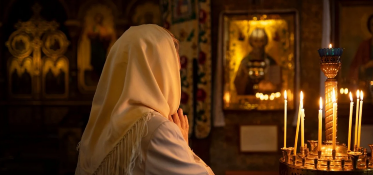 Жінка молиться перед іконою