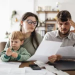 Подружжя з дитиною читають документи