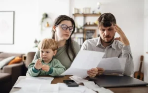 Подружжя з дитиною читають документи