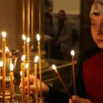 Девочка ставит свечу