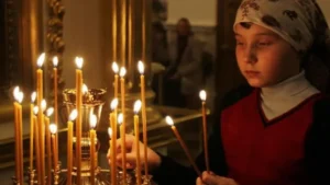 Девочка ставит свечу