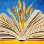 Розгорнута книга на фоні українського прапора