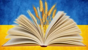 Розгорнута книга на фоні українського прапора