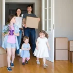 Сім’я з коробками заходить у кімнату