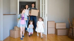 Сім’я з коробками заходить у кімнату