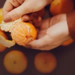 Жінка чистить мандарин