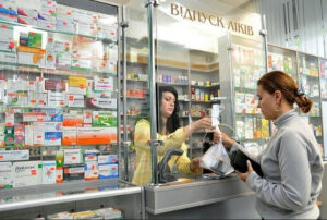 Жінка купує ліки в аптеці