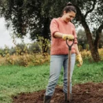 Жінка з заступом на городі